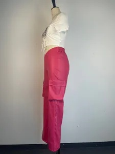 Side profile detail of vibrant pink PU leather cargo pants with large utility pockets