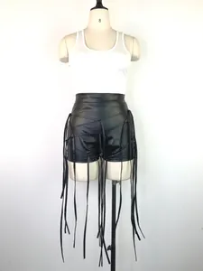 Close-up van sexy zwarte PU-leren korte broek met lange gevlochten kwastjesfranjes