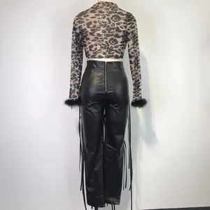 Achteraanzicht van modieuze luipaard crop top en zwarte PU-leren broek met veters.