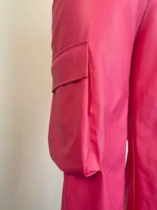 Close-up detail of the side cargo pocket on vibrant fuchsia PU leather straight pants