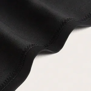 Detailed close-up view of overlock stitching and high-stretch fabric texture on black dress