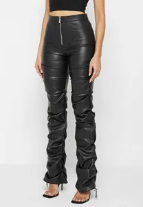 Detalle de los pantalones de cuero sintético fruncidos para mujer con ajuste slim y cremallera