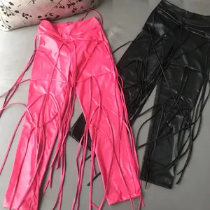 Detailweergave van de roze en zwarte PU-leren broek met decoratieve veters en franjes