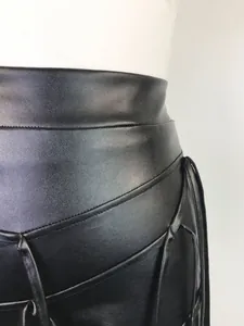 Detailopname van zwarte PU-leren short met een ingewikkeld geweven touwontwerp.