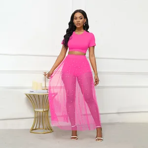 Dettaglio del set gonna in rete fucsia con decorazioni di perle e top corto corto