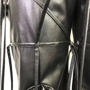 Detailopname van zwarte PU-lederen broek met ingewikkeld vetersysteem en stiksels.