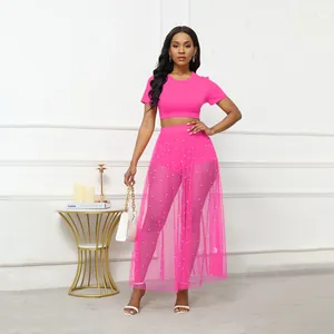 Dettaglio della trama dell'outfit rosa a tre pezzi con gonna in rete con perle
