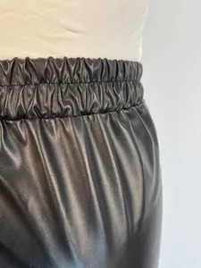 High-quality close-up showing elastic waistband detail on women black PU leather pants