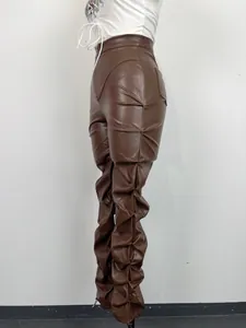 Detalle de perfil de pantalones de cuero PU marrón con diseño de pliegues y textura