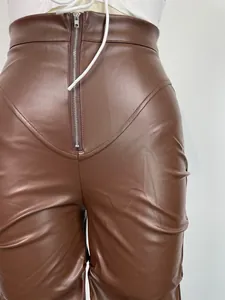 Detalle de pantalones de cuero PU marrón con cintura alta, cremallera frontal y fruncidos
