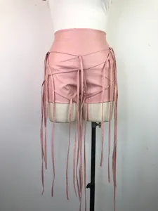 Detailweergave van roze PU-lederen shorts met ingewikkelde vlecht- en franjedetails