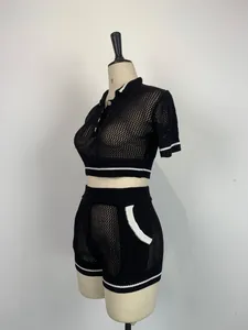 Vue détaillée d'un ensemble sport deux pièces en maille noire avec rayures blanches.