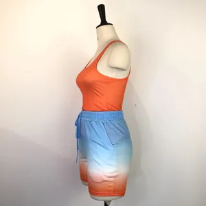 Side view of women's 2-piece sports set with orange racerback tank and gradient shorts