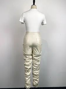 Vista posterior de elegantes pantalones fruncidos de cuero PU beige en un maniquí de ropa