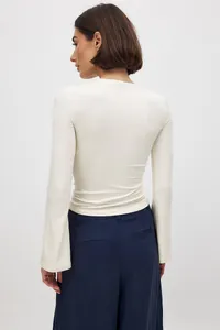 Vista posterior de un elegante top blanco crema ajustado con mangas acampanadas