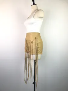 Zijaanzicht detail van kaki PU-leren short met lange kwastjes en vlechtjes hier