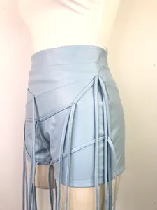 Detailopname van lichtblauwe PU-leren short met ingewikkelde veter- en franje-elementen.