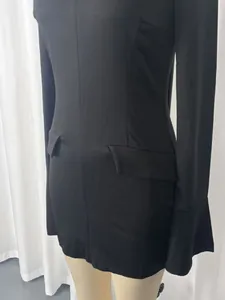 Close-up of black slim fit mini dress featuring flared cuffs and waist flaps detail.