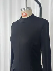 Detailed view of a sleek black long-sleeved bodycon dress displayed on a professional mannequin