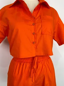 Dettaglio ravvicinato di un set coordinato con camicia a maniche corte arancione