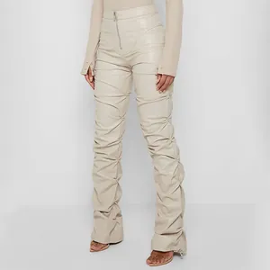 Pantalones de cuero sintético beige con cintura alta y modernos detalles fruncidos.