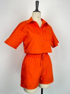 Dettaglio camicia arancione a maniche corte e pantaloncini con elastico in vita abbinati