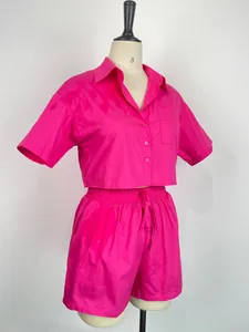Dettaglio del completo rosa due pezzi con camicia a maniche corte e pantaloncini