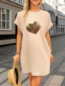 Close-up view of the golden sequin heart embroidery on a beige casual short sleeve dress