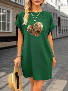 Green loose-fit casual dress featuring a large gold sequin heart embroidery on the chest.