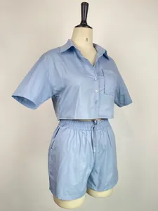 Dettaglio di un set camicia a maniche corte azzurra e pantaloncini elastici su manichino.