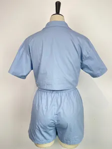Vista posteriore di un completo due pezzi azzurro con camicia e pantaloncini donna