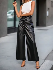 Détail du pantalon large en similicuir noir à taille haute avec fermeture éclair et nœud