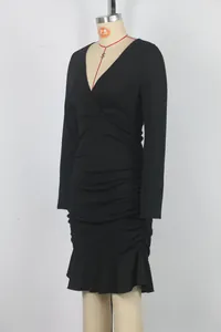 Detailed side view of a black long-sleeved V-neck ruched bodycon dress with ruffled hem