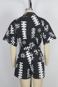 Back view of a short-sleeved romper jumpsuit with white tribal print on black fabric