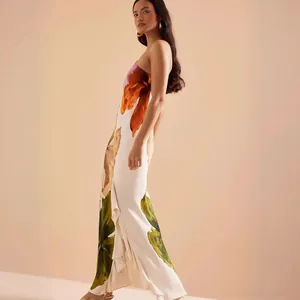 Detailed side view of an elegant floral maxi dress with ruffled hem and backless design for vacation.
