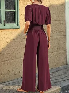 Back view of an elegant burgundy short sleeve wide leg jumpsuit with smocked waist