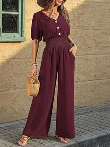 Detailed view of elegant burgundy short sleeve wide leg jumpsuit with smocked waist design