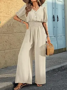 Elegant short-sleeved jumpsuit in beige featuring a smocked waist and wide-leg trousers design