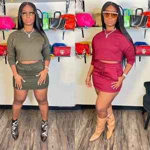 Detailed view of women's olive and burgundy two-piece skirt set with long sleeve crop top.