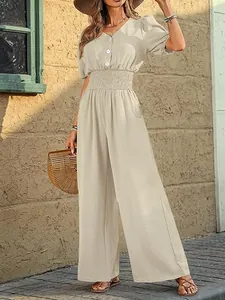 Elegant short-sleeved wide-leg jumpsuit with a smocked waist and button-down front.
