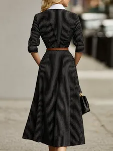Dettaglio posteriore di abito a righe vintage con colletto bianco e cintura marrone