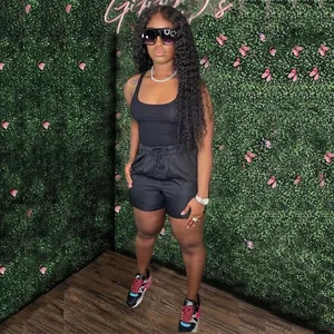Full body view of a stylish black racerback tank top and casual shorts set on a model