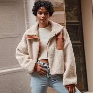 Detailed view of women's cream sherpa jacket with brown PU leather patchwork details.
