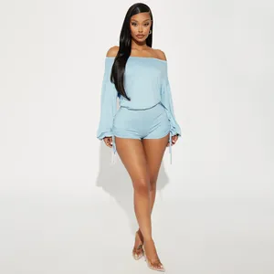 Full-length studio shot of a light blue off-the-shoulder long sleeve ruched drawstring romper