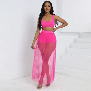 Set sexy tre pezzi rosa con top corto, pantaloncini e gonna in rete plissettata trasparente.