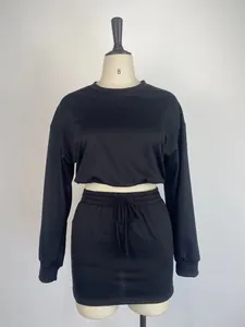 Detail of black two-piece set with long-sleeve crop top and bodycon mini skirt.