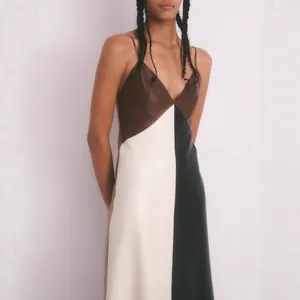 Détail de la robe caraco en similicuir bicolore avec décolleté en V et coupe ajustée