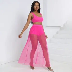 Vista dettagliata del set rosa a tre pezzi con crop top, pantaloncini e gonna in rete