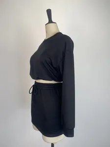 Detailed side view of women's black 2-piece set featuring a long sleeve crop top and mini skirt