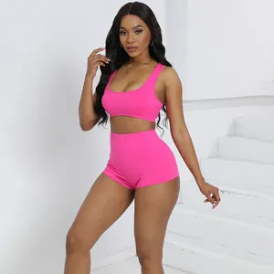 Completo sportivo rosa acceso due pezzi con crop top e pantaloncini a vita alta su modella